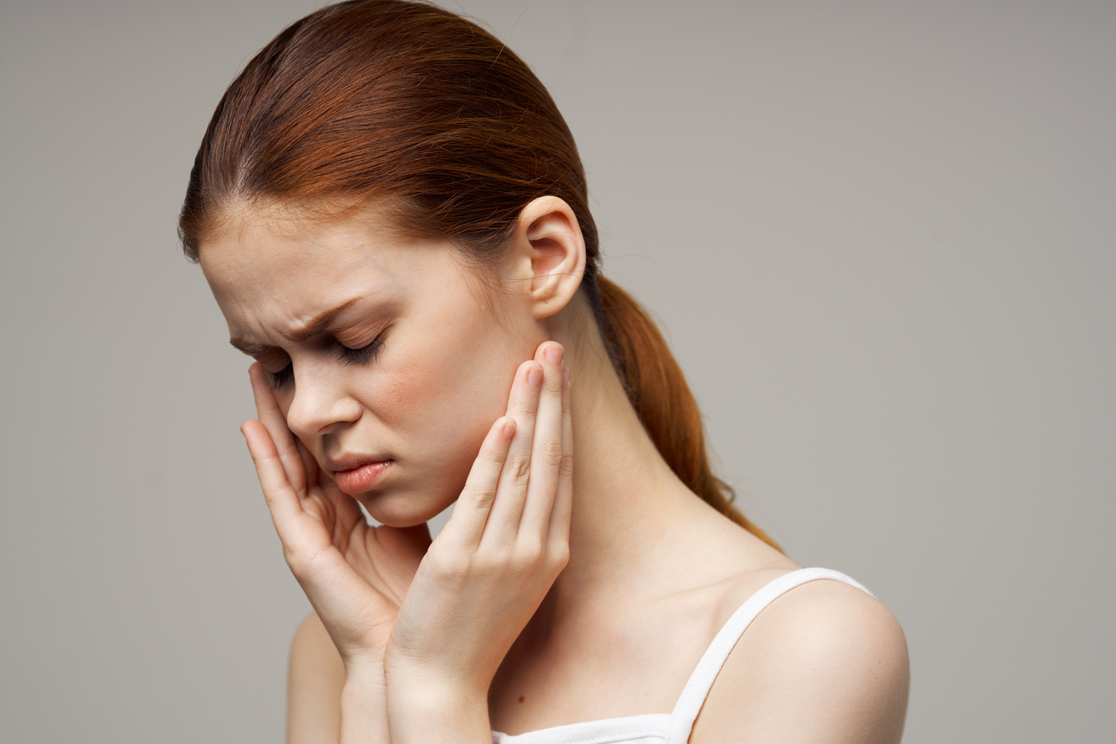 Woman Holding on to Face Pain in Teeth Studio Treatment